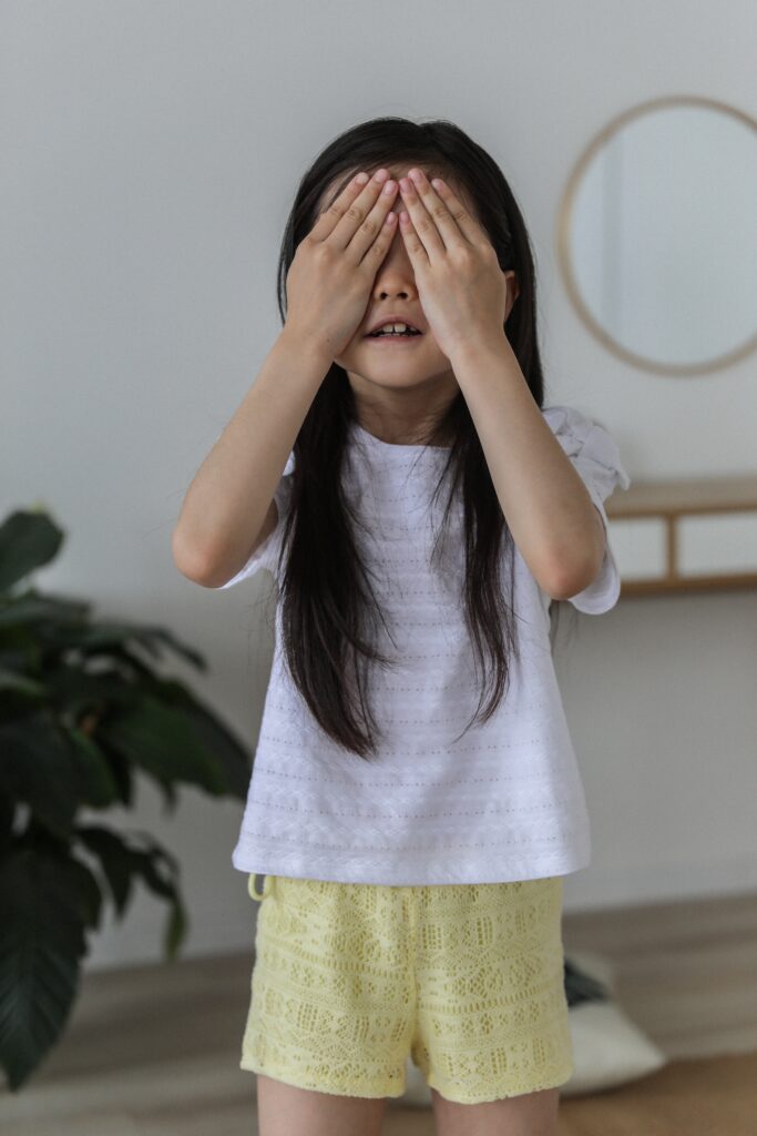 young girl covering her eyes