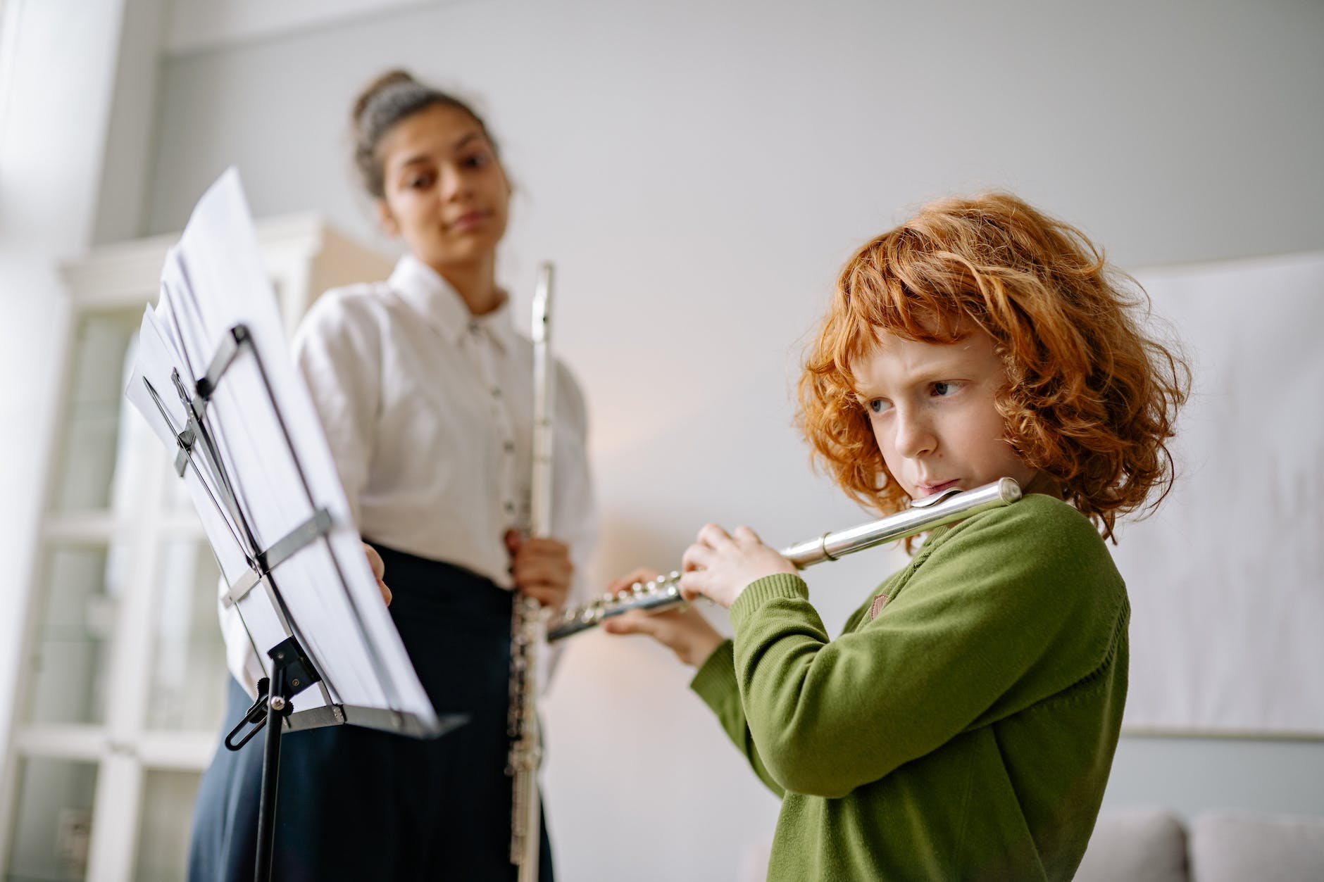 girl in green sweater playing flute