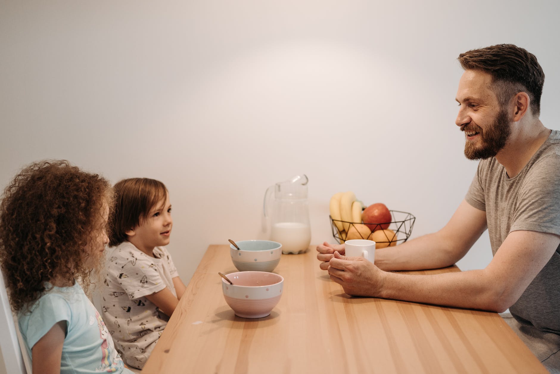 a man talking to his kids while having breakfast