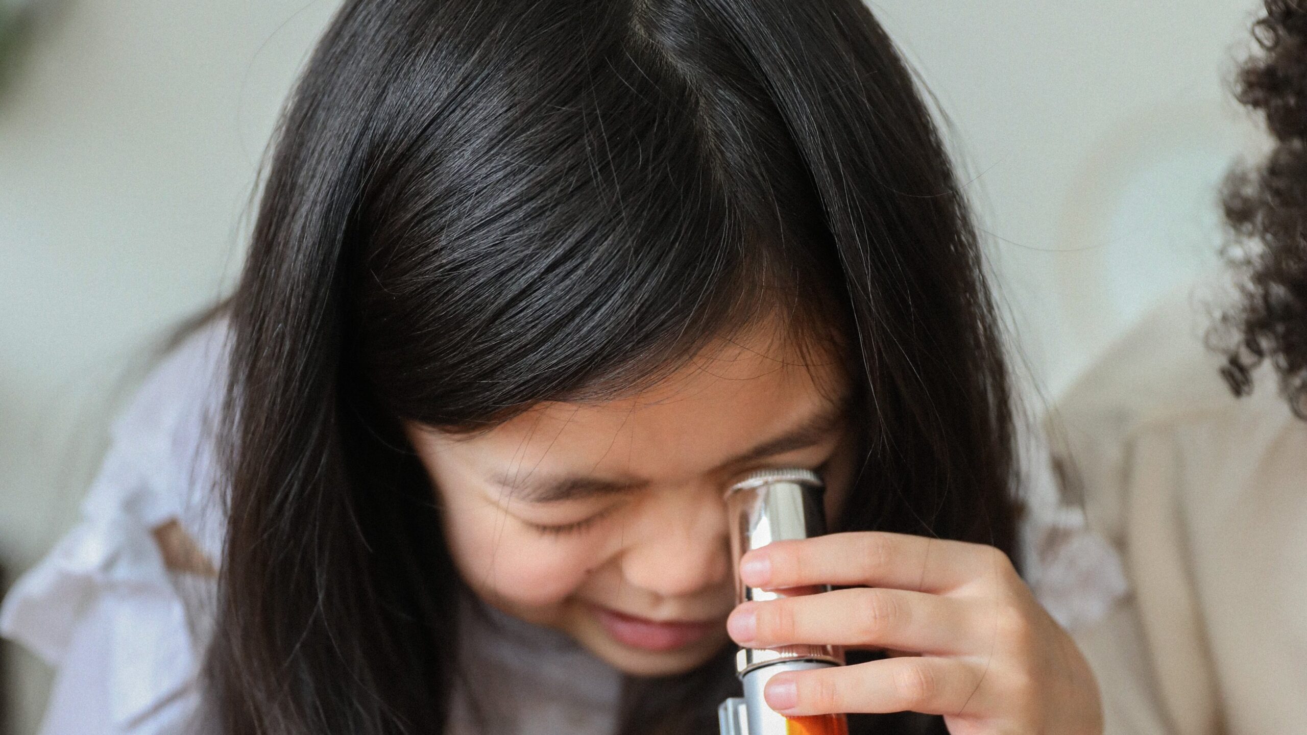girl looking into a microscope