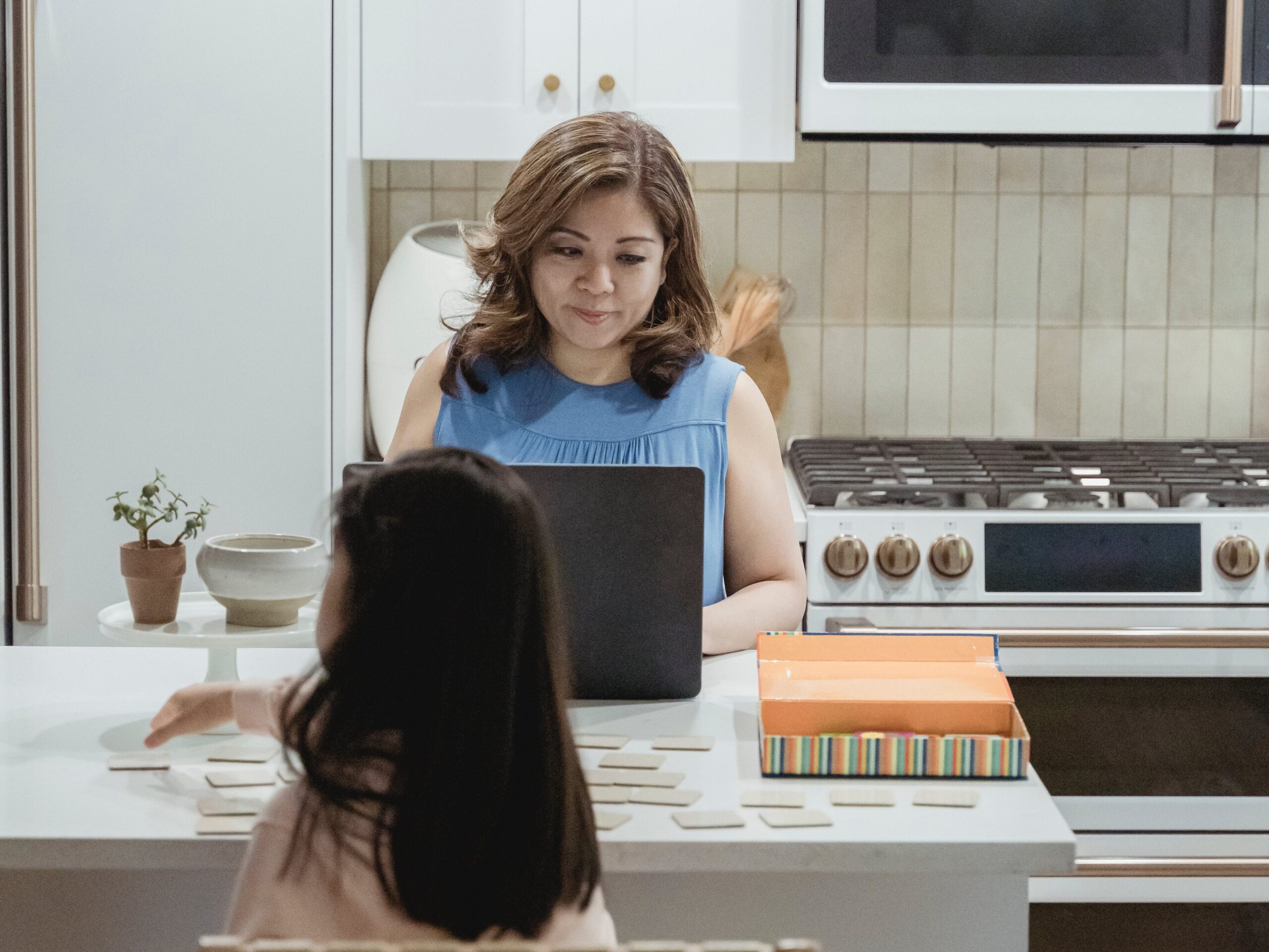 mother on laptop in kitchen