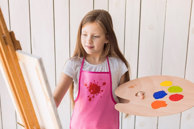 young girl painting on easel
