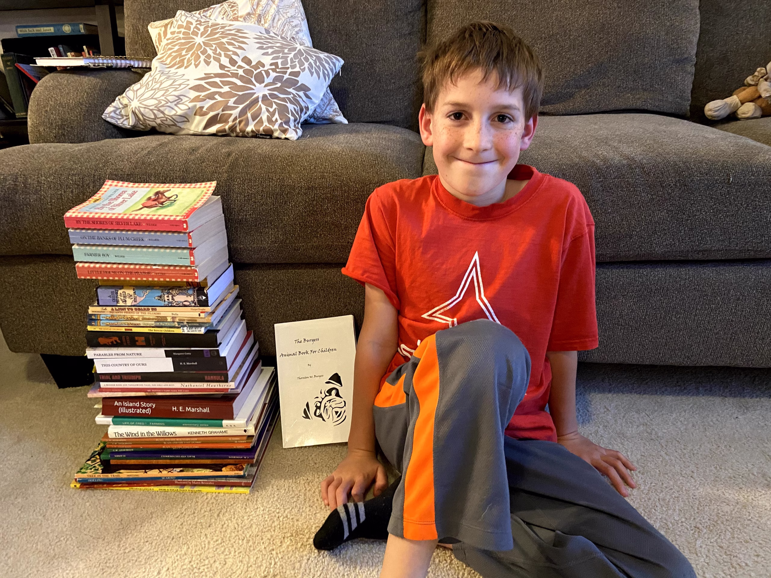 boy sitting with stack of books