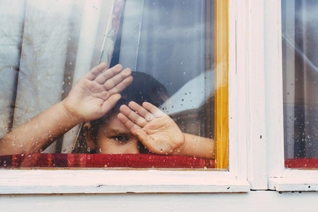 boy looking out the window on a rainy day