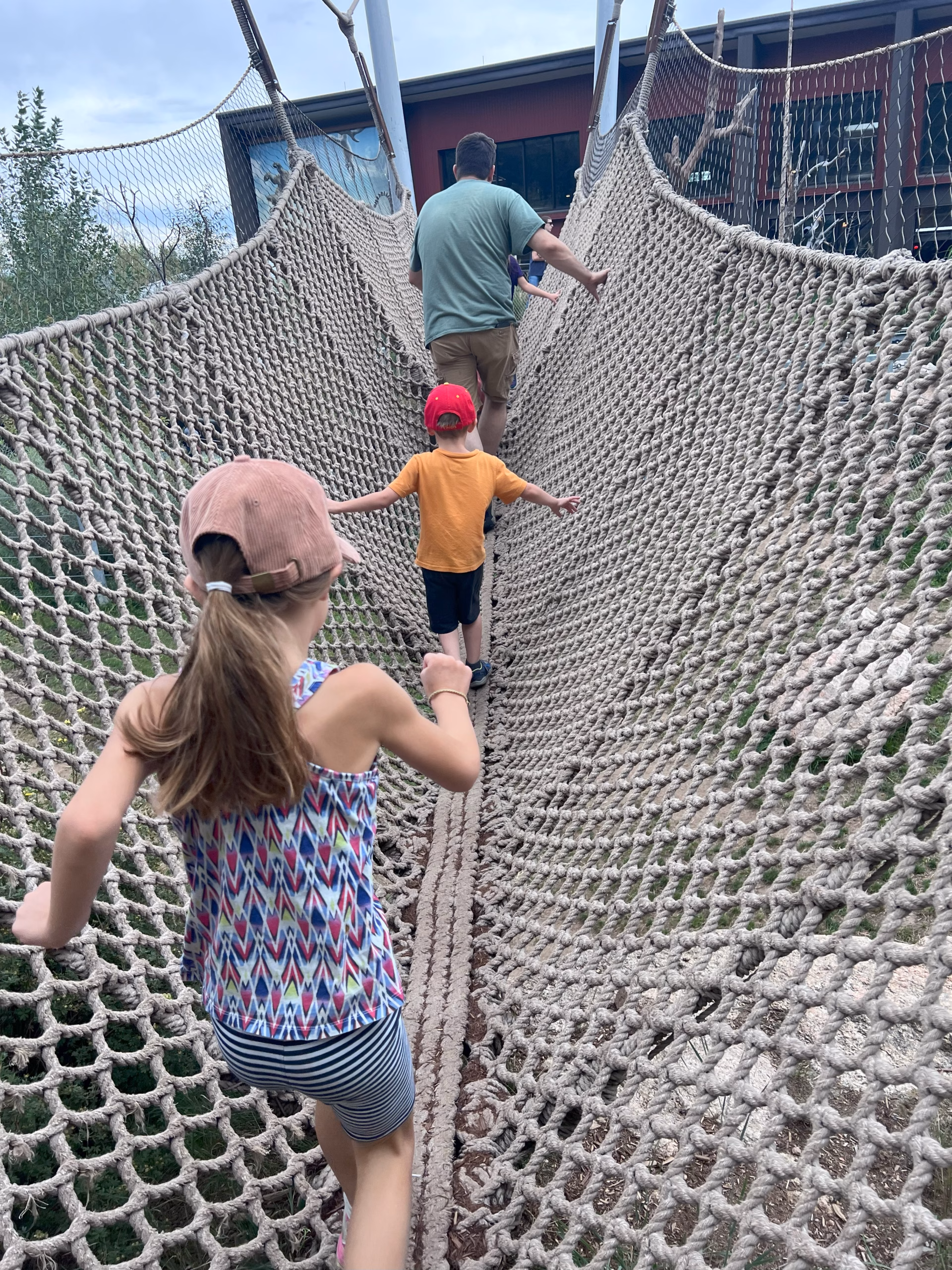 family walking on a rope bridge