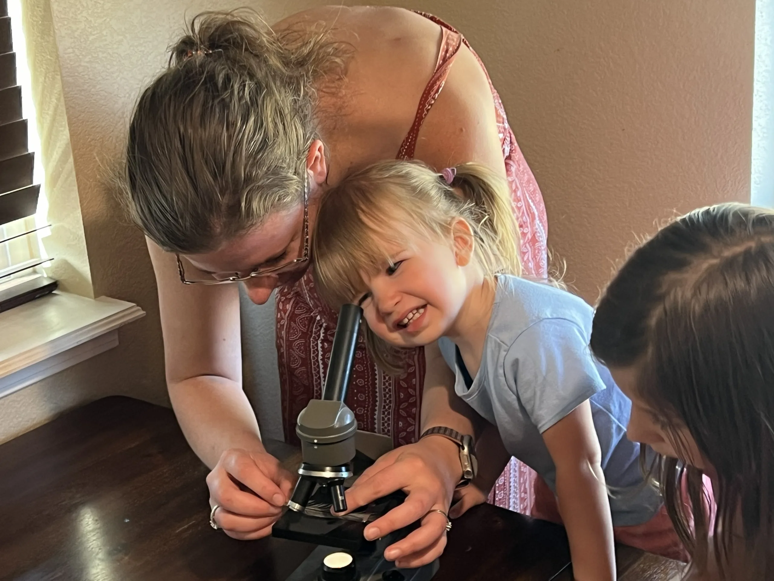 A parent and child looking through a microscope together